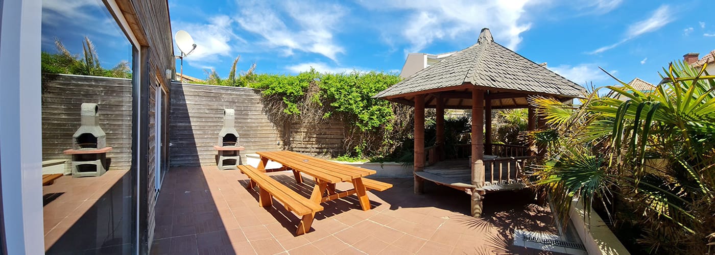 appart hôtel pasino n°8, le patio il est équipé d'une grande table et ses deux bancs, d'un barbecue et un gasebo donne une touche exotique à l'espace